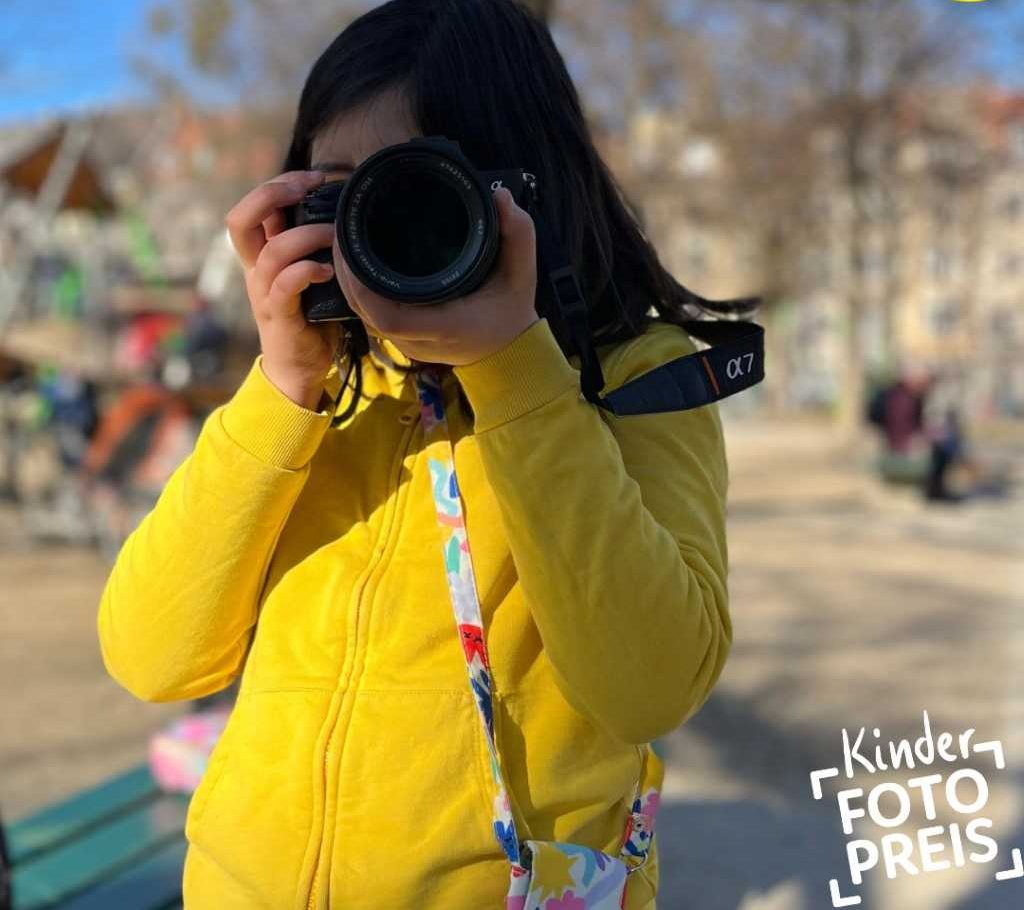 Mädchen mit Kamera - Beschriftung Fotopreis