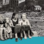Kinder sitzen vor Trümmern